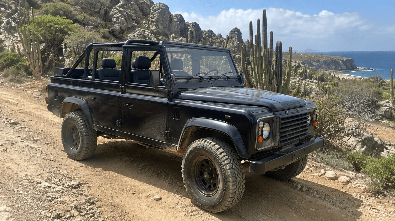 Rugged black off-road 4x4 parked on a dirt trail near rocky cliffs in Curaçao's countryside