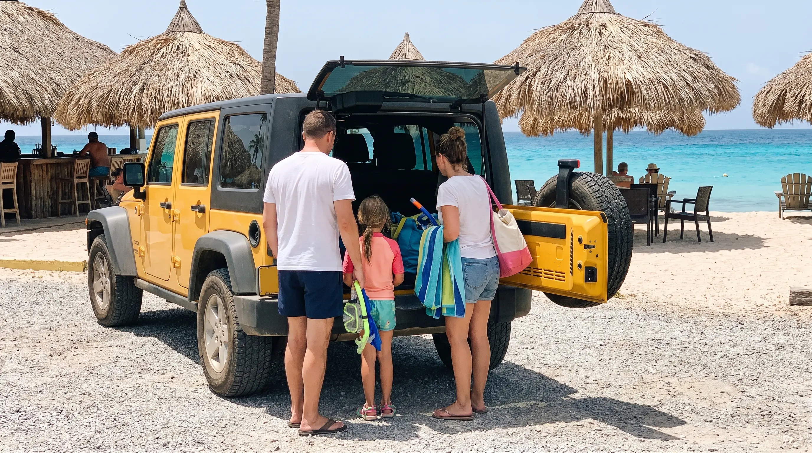 Familie entlädt Strandausrüstung aus einem gelben Jeep am Jan Thiel Beach auf Curaçao