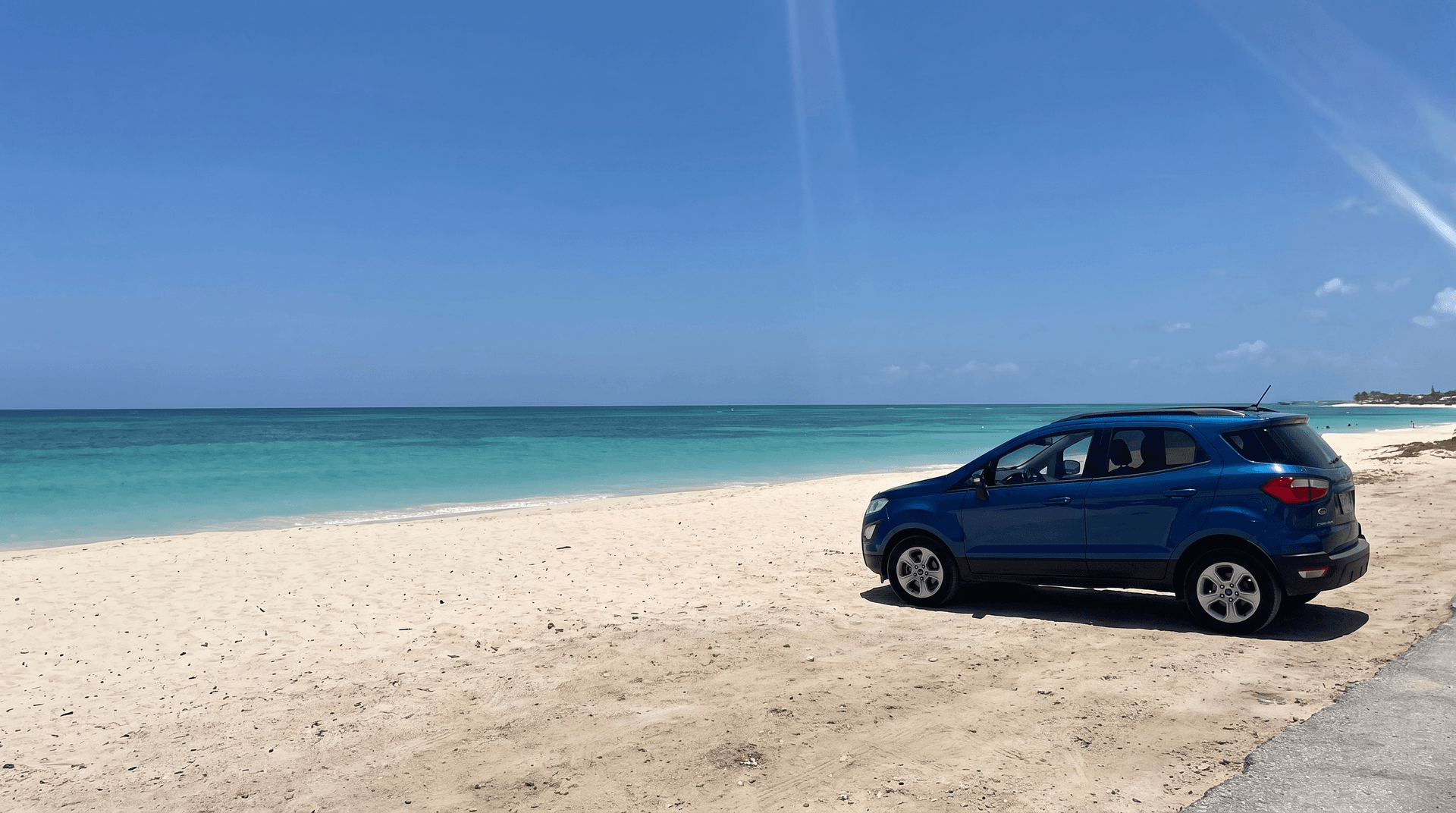 Compact SUV parked near the sand at Palm Beach, Aruba