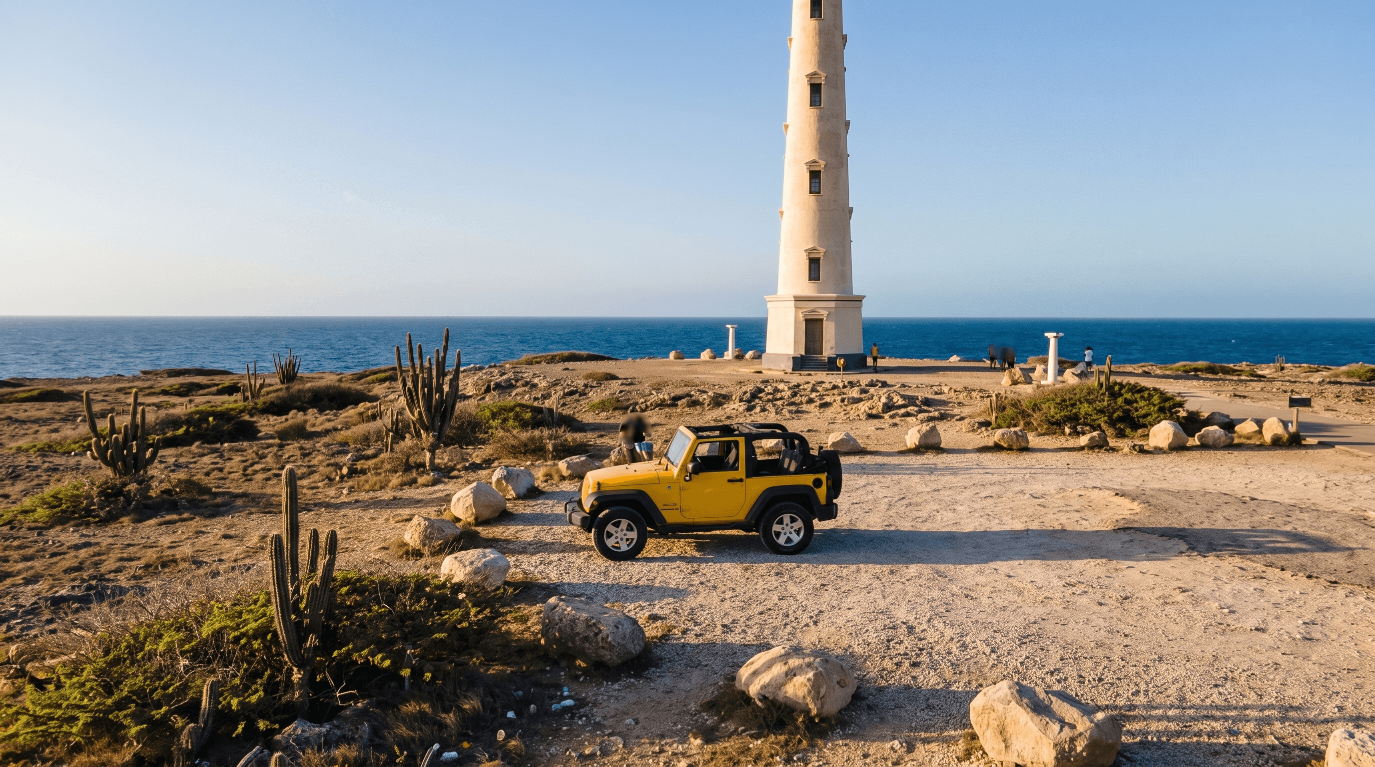 Yellow open-top Jeep parked on the gravel area beside the California Lighthouse on the northwest point of Aruba